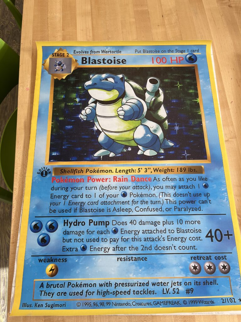 a blastoise pokemon card blown up to a poster size and glued onto poster board. 