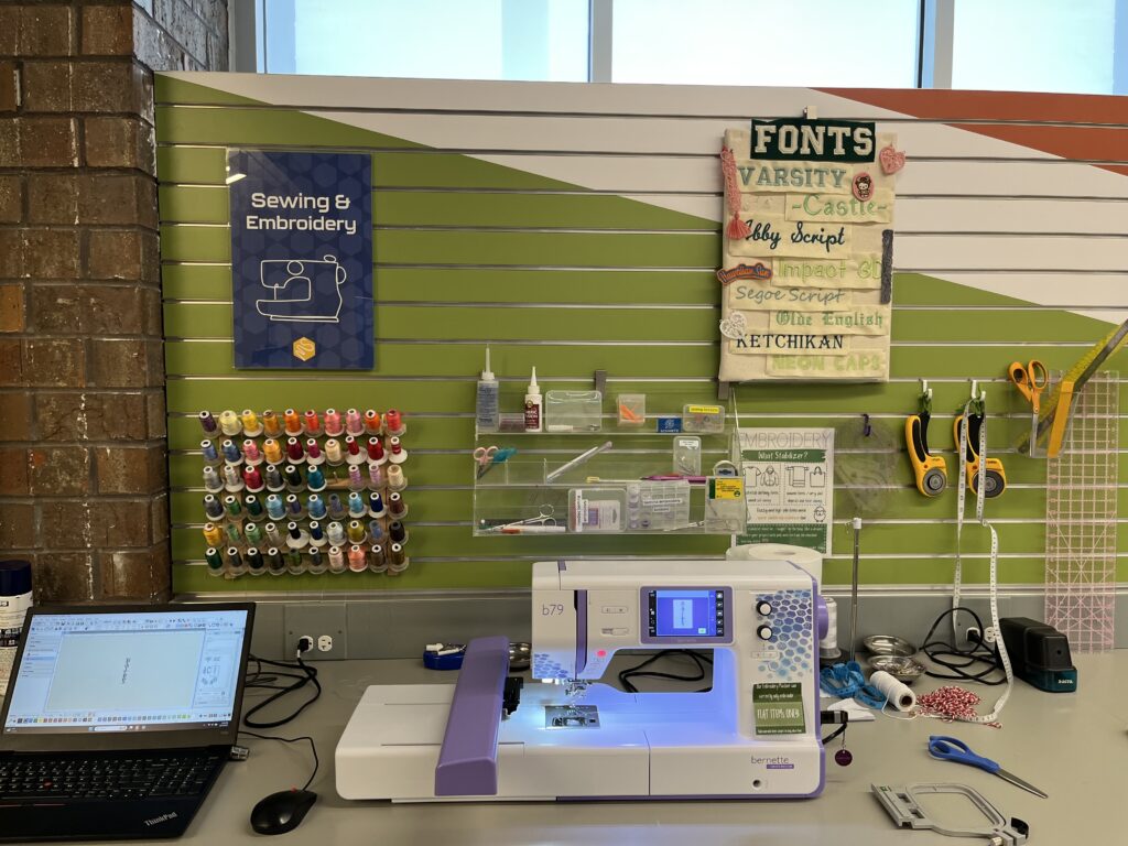 The sewing and embroidery machine station, showing off the multiple colors of thread and different font options. 